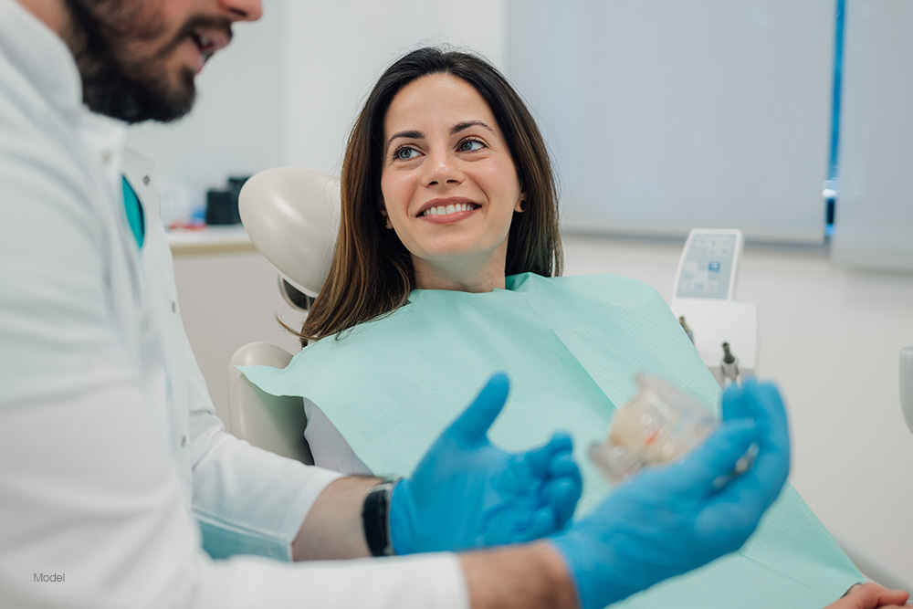 Woman at the dentist talking with the doctor in the examination chair