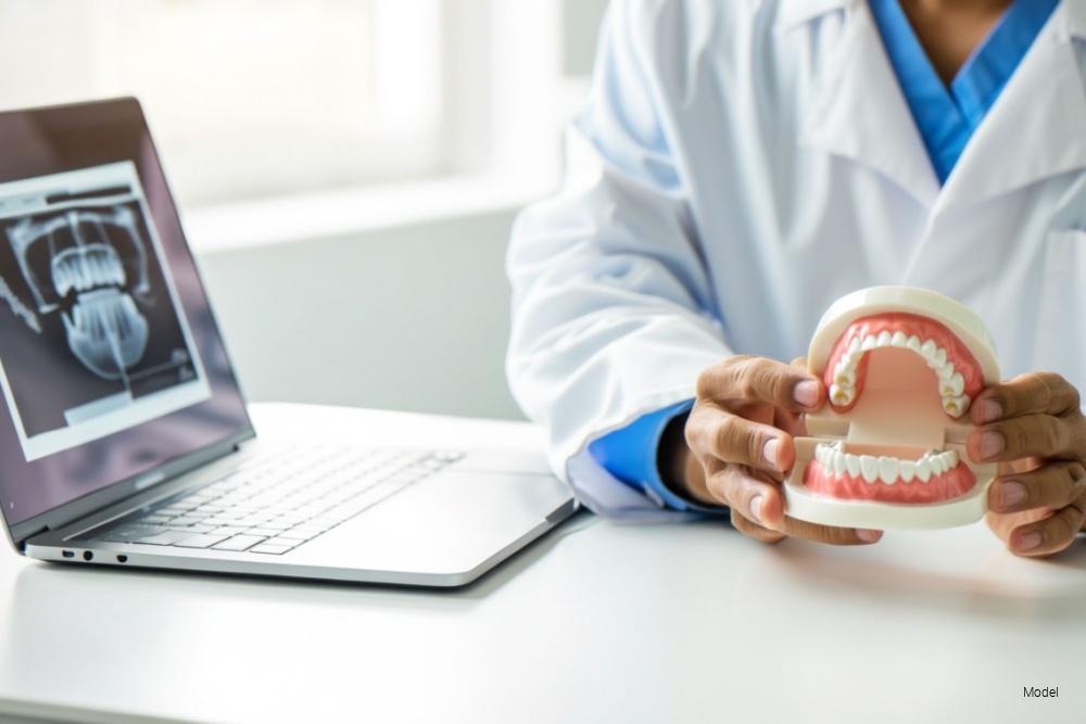 dentist using a model of teeth and gums to go over dental health